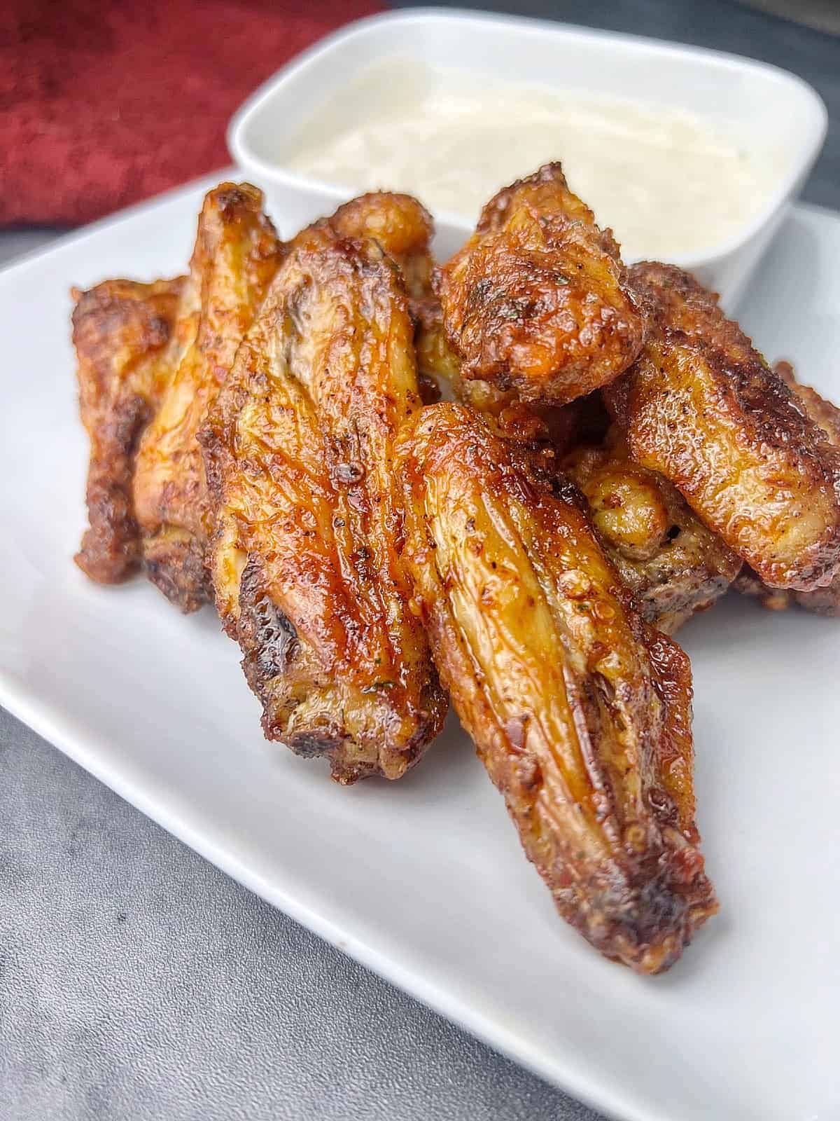 https://kscuisine.com/wp-content/uploads/2023/12/frozen-chicken-wings-in-air-fryer-with-hot-sauce-1.jpg